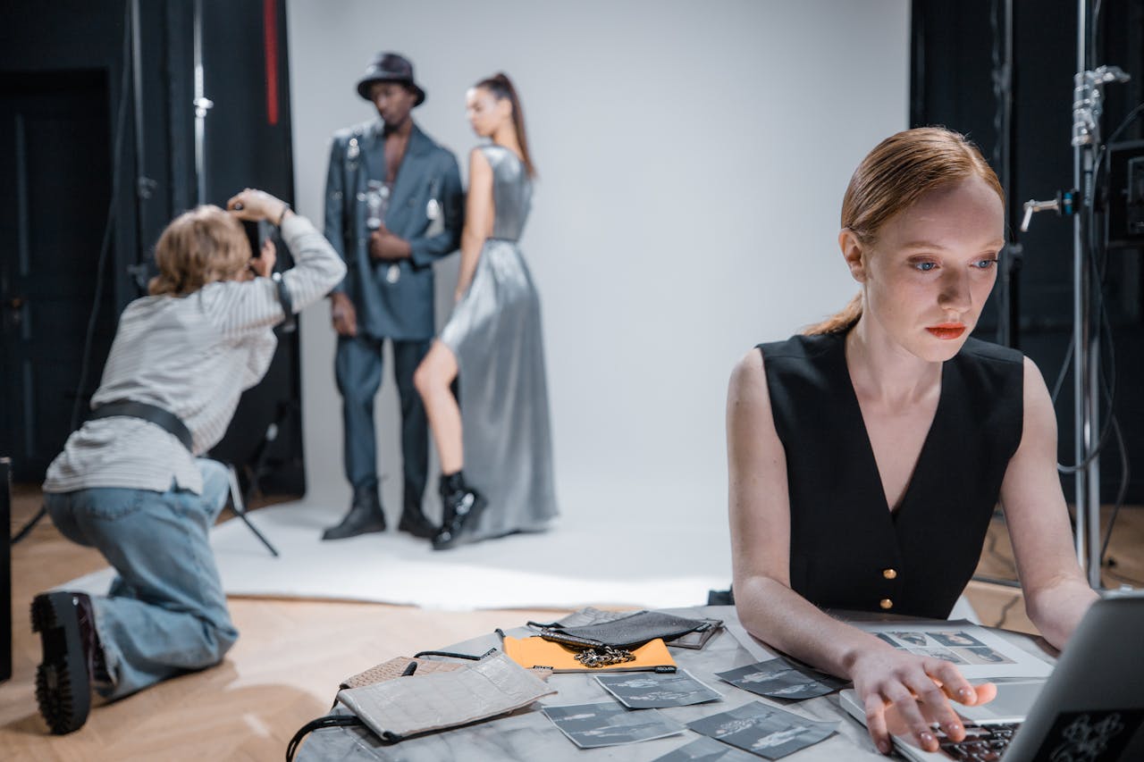 Photographer capturing fashion models during a professional photoshoot in a modern studio setting.